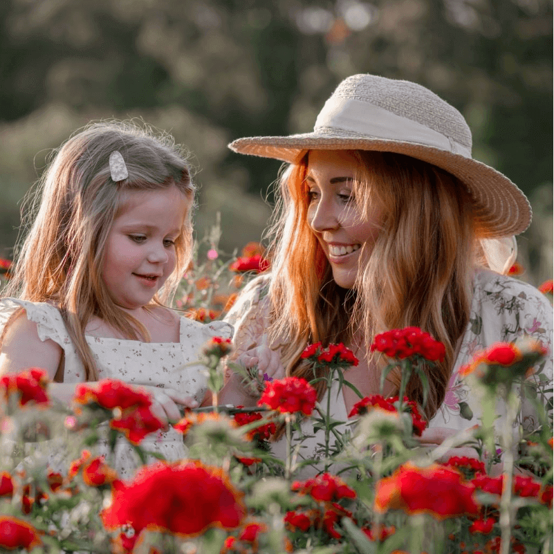 mother and child in flower field happy