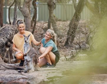 two tourists amongst free ranging kangaroo and wallaby