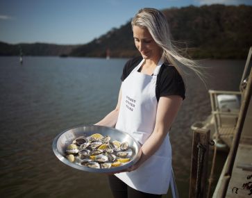 woman holding oysters at mooney mooney oyster farm tour