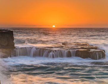 ocean on rocks at sunset