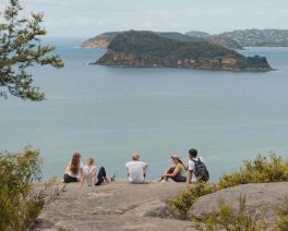 People on a clifftop overlooking Bouddi 