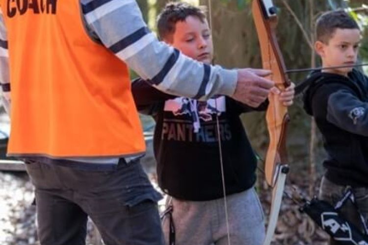 child being taught archery