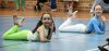 Two dancers posing on the floor, smiling.