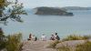 People on a clifftop overlooking Bouddi 