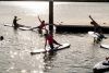 people doing yoga on stand up paddle boards on the lake